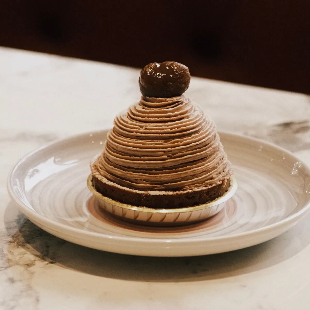 Le Mont-Blanc de Camille : vermicelles de crème de marron et marron glacé, sur une assiette en céramique