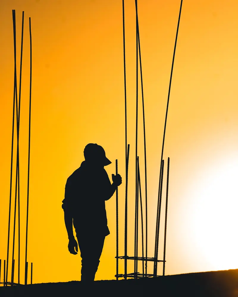 Karim : silhouette d'un ouvrier casquette sur la tête, contrôlant des fers en attente (photo d'illustration)