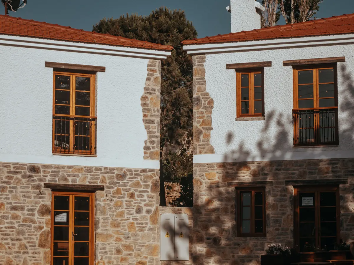 Maison rénovée associant soubassement en pierre apparente et étage enduit